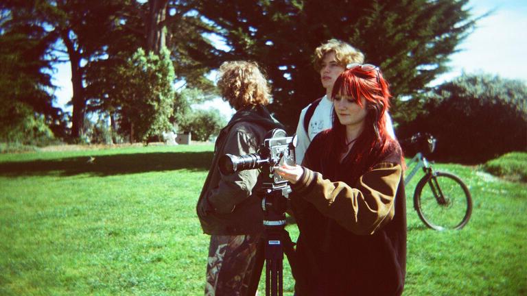 USF students filming in the grass on campus