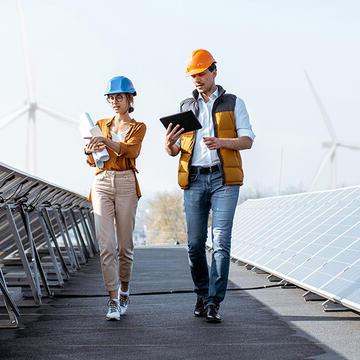 two people walking along a solar farm